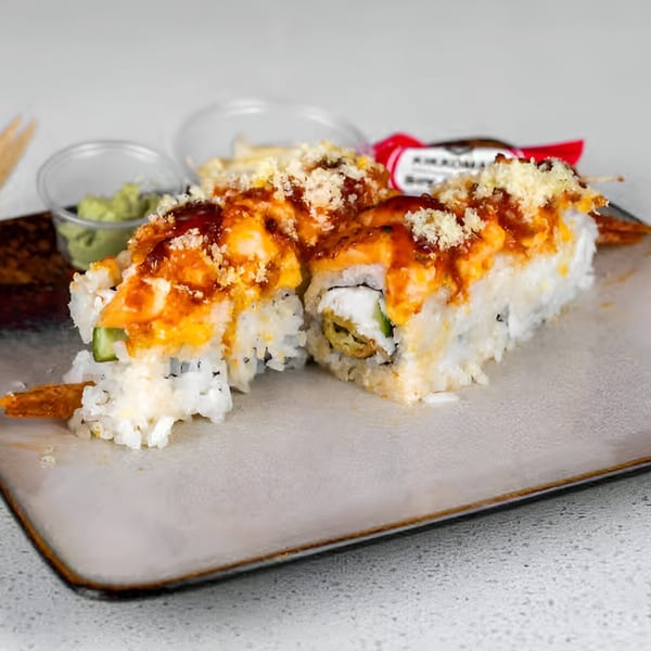 Sushi Totoro's crispy shrimp tempura rolls with orange sauce and crunchy toppings, served with wasabi.