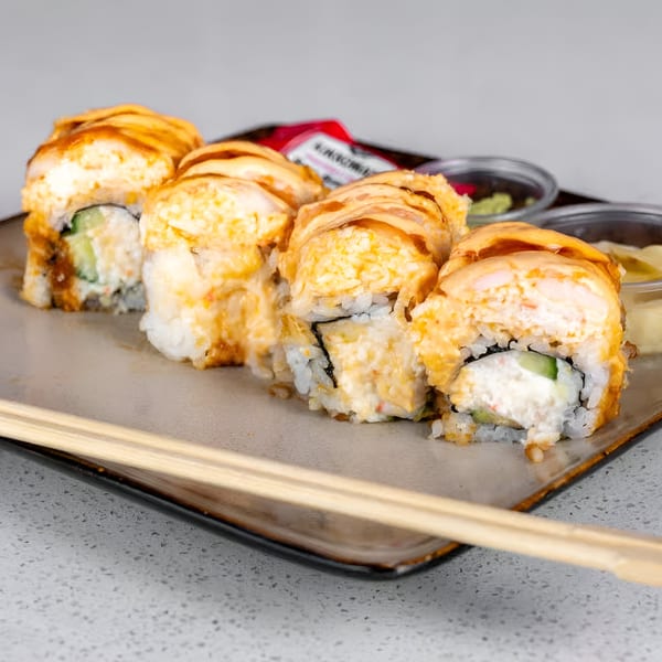 Sushi Totoro's baked sushi rolls with creamy topping, cucumber, and cream cheese, served with chopsticks.