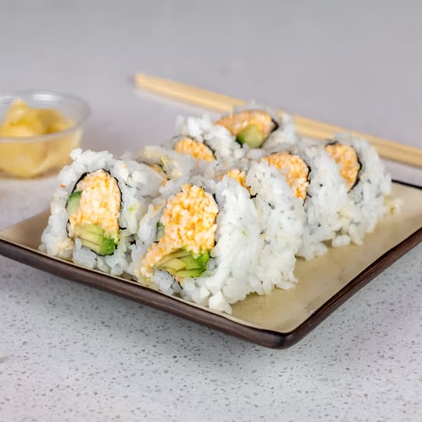 Sushi Totoro's California rolls with avocado and orange filling, served on a rectangular plate with chopsticks.